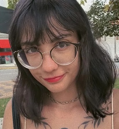 Foto de Larissa da Silva Pereira uma menina branca de cabelos castanho escuro com um oculos redondo esta sorrindo para a foto